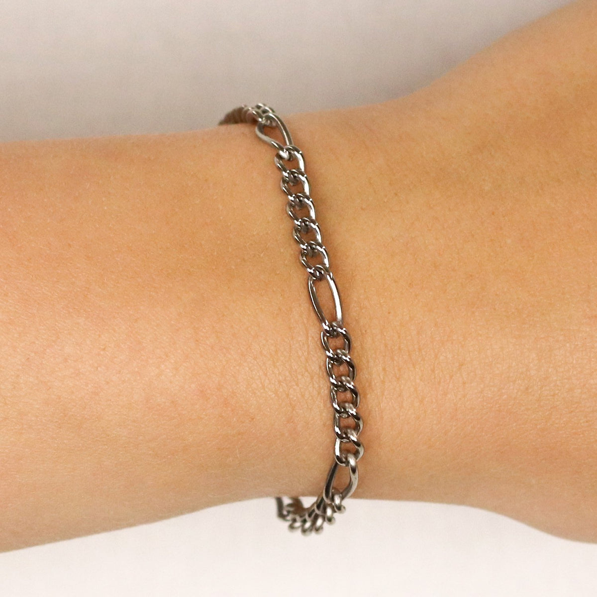 De Boccia Titanium Armband 03051-01, een zilverkleurige figaro schakelarmband van het merk Boccia, schittert prachtig om de pols en komt mooi uit tegen een lichte achtergrond.