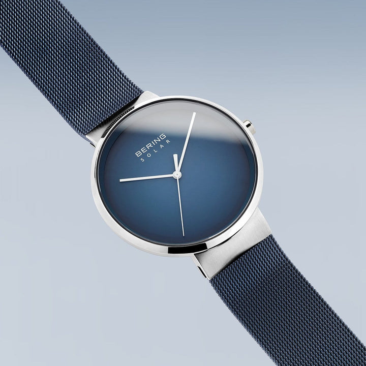 Het Bering unisex horloge 14339-307 heeft een strak, minimalistisch design met een blauwe wijzerplaat en zilveren kast, aangevuld met een blauwe mesh band. Een elegant accessoire voor liefhebbers van moderne stijl.