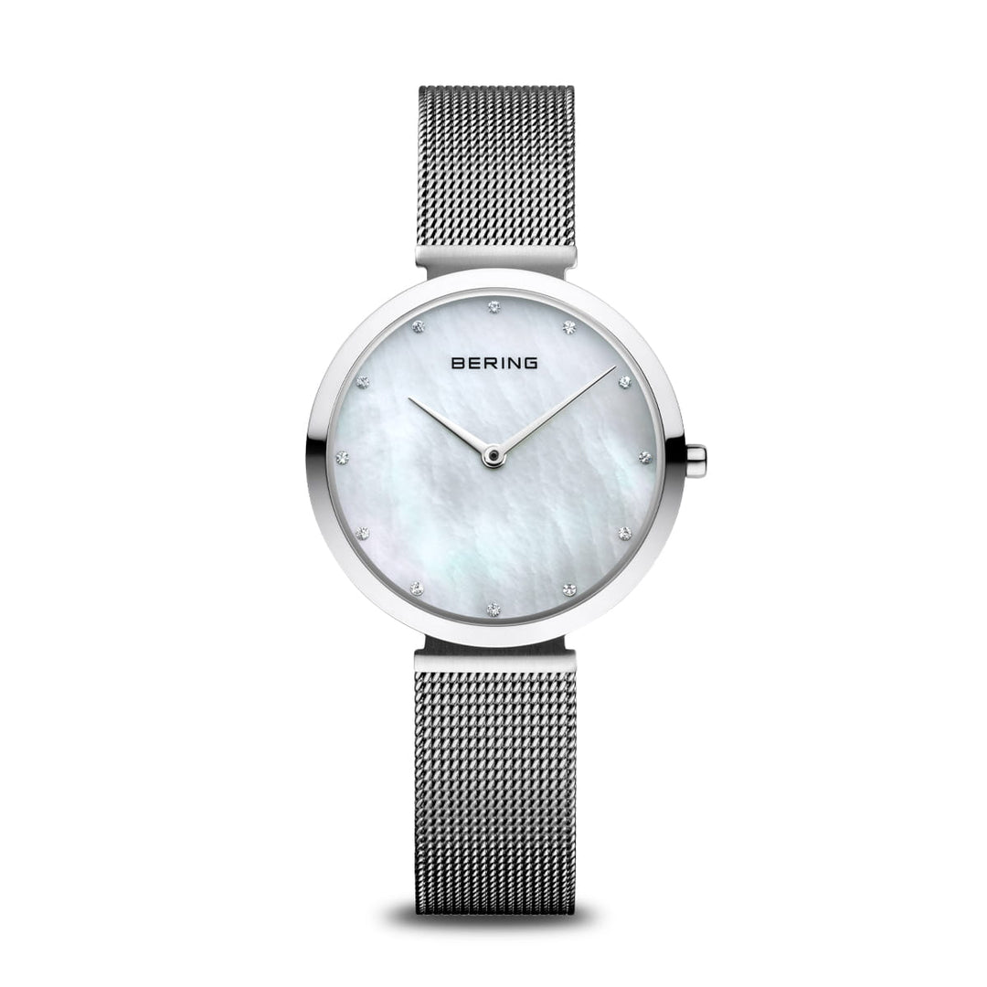 Het Bering 18132-004 dameshorloge heeft een witte parelmoer wijzerplaat in een roestvrijstalen kast. Een zilveren mesh band en kleine kristallen markeringen accentueren de minimalistische wijzers, met Berings naam bovenaan in het midden onder saffierglas.