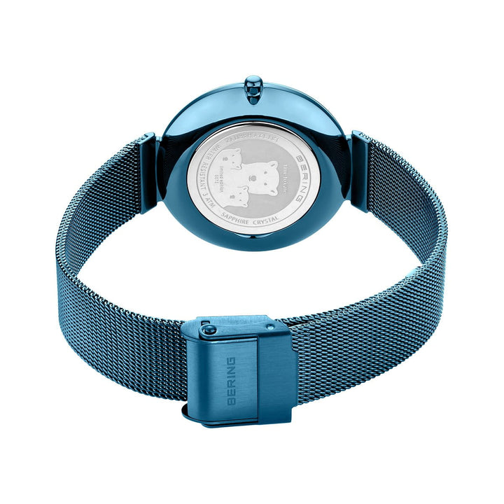 Een Bering dames horloge blauwe wijzerplaat - 18132-Charity1 wordt getoond vanaf de achterkant, met de nadruk op de blauwe mesh band, gesloten sluiting en gegraveerde roestvrijstalen achterkant van de kast met Bering logo's.