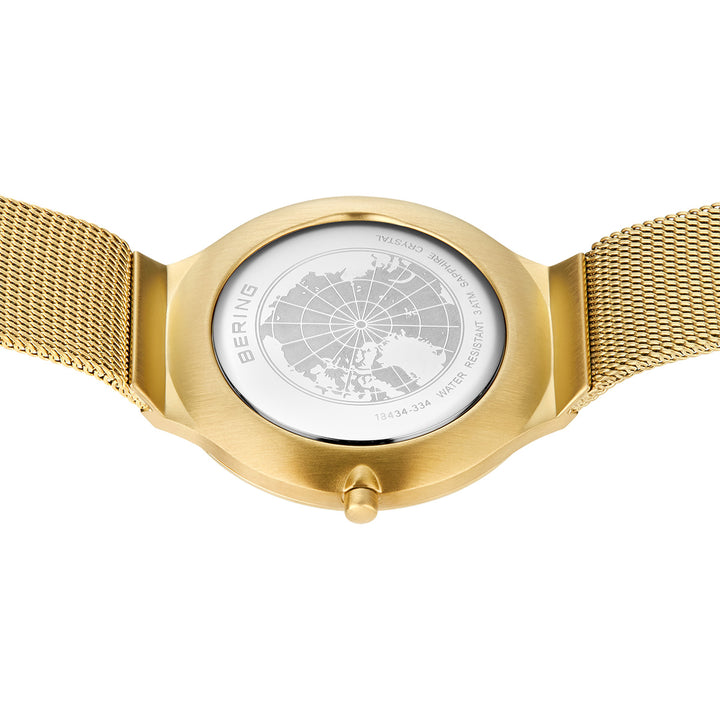 Op de achterkant van het Bering dameshorloge goud - 18434-334 is een wereldkaart gegraveerd op de gouden meshband van het horloge, met het label BERING en informatie over de waterbestendigheid en het modelnummer.