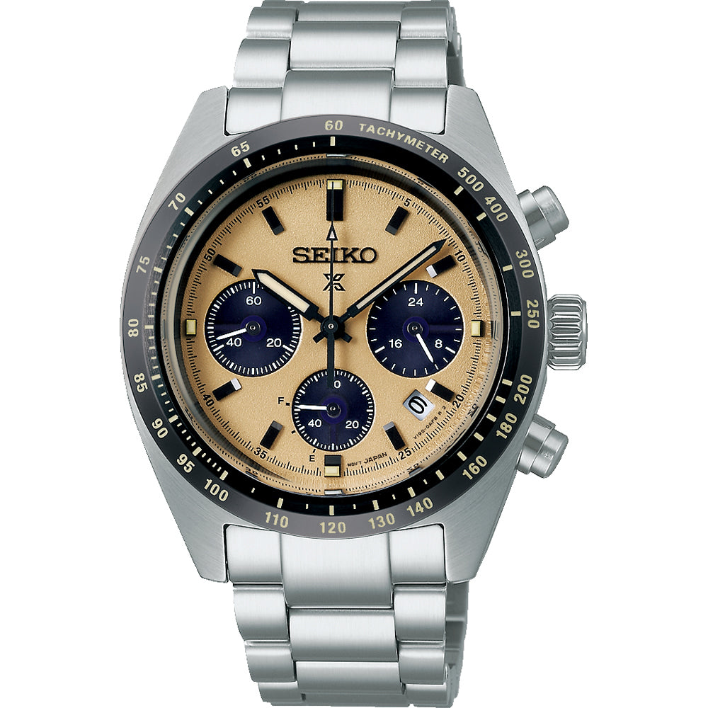 De Seiko Prospex SSC817P1 is een zilveren herenhorloge met een metalen band, beige wijzerplaat, drie zwarte subdials, saffierglas, datumvenster, zwarte tachymeter bezel en lichtgevende wijzers. De kroon en pushers zitten aan de rechterkant.