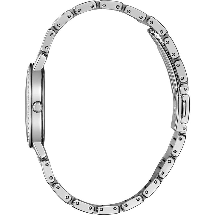 Zijaanzicht van het slanke Seiko dameshorloge SUP467P1 van roestvrij staal, met een gekoppelde band, dunne ronde kast, parelmoeren wijzerplaat, zonne-uurwerk, zijkroon en vouwsluiting horizontaal geplaatst tegen een witte achtergrond.