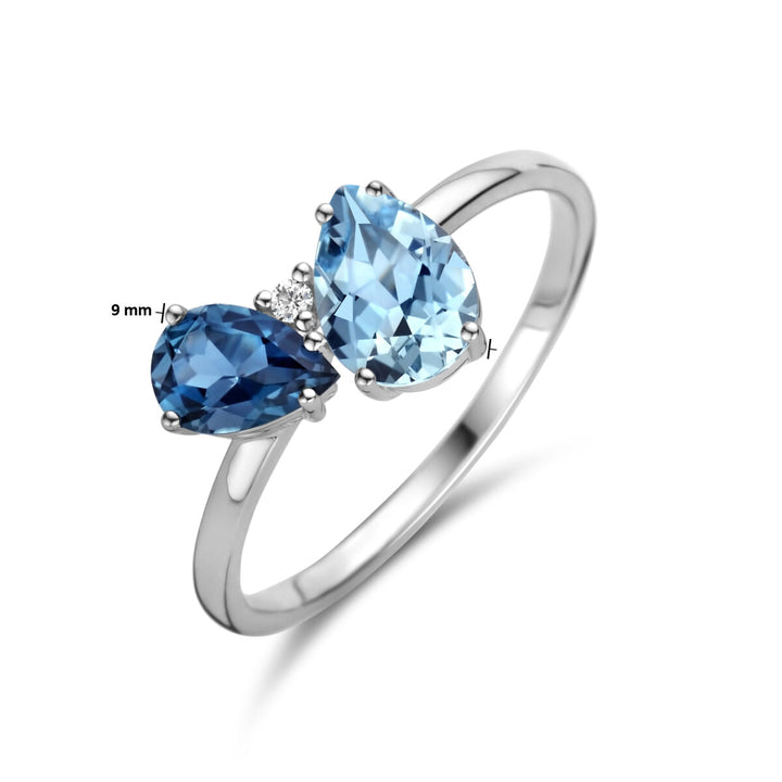 De Van der Kooij Collectie ring trilogie bestaat uit London blauw topaas, blauw topaas en een 0.01ct H/P1 diamant in 14K witgoud, met links een peer geslepen edelsteen van 9 mm.