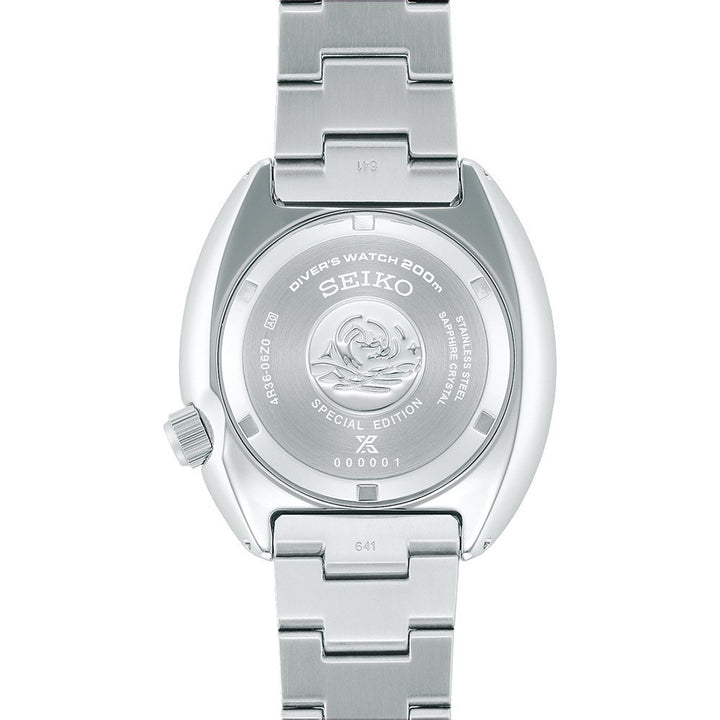 De afbeelding toont de achterkant van een Seiko Prospex heren horloge SRPK01K1 duikhorloge, met gegraveerde tekst en een decoratief ontwerp. Dit speciale zilveren exemplaar wordt geleverd met een metalen band en een automatisch uurwerk voor nauwkeurige tijdwaarneming.