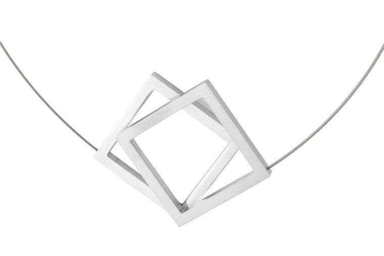 Srebrny naszyjnik z dwoma dużymi, geometrycznymi kwadratami.