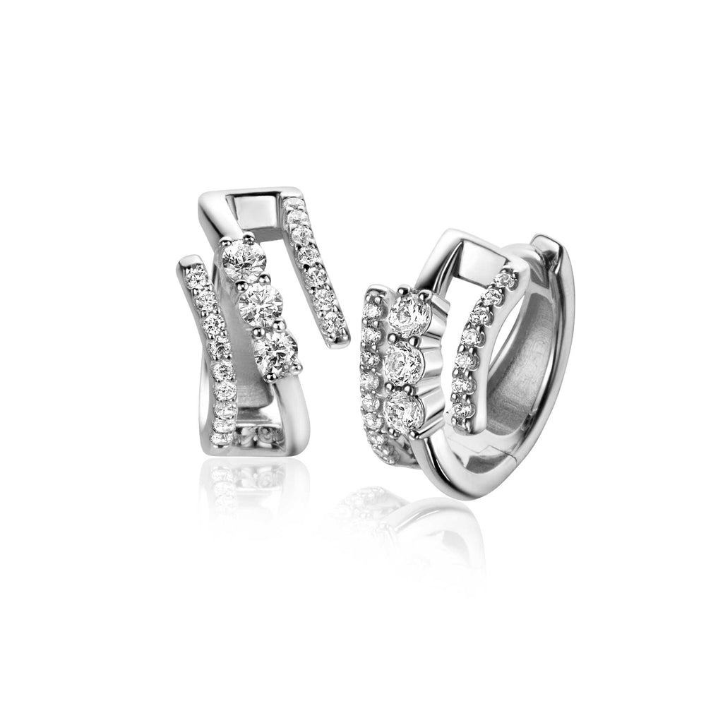 Een paar elegante Zinzi oorbellen zilver ZIO2645 van Zinzi, met een modern asymmetrisch ontwerp met rijen sprankelende steentjes op elke oorbel, weergegeven op een witte achtergrond met een subtiele reflectie.