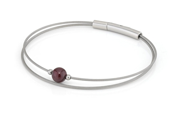 De minimalistische Thinking of You armband Granaat zilver A718B van CLIC Creations heeft twee dunne zilveren draden met een enkele rode Granaat kraal. Handgemaakt in Nederland, het bevat een strakke cilindervormige zilveren sluiting voor een moderne en elegante look.