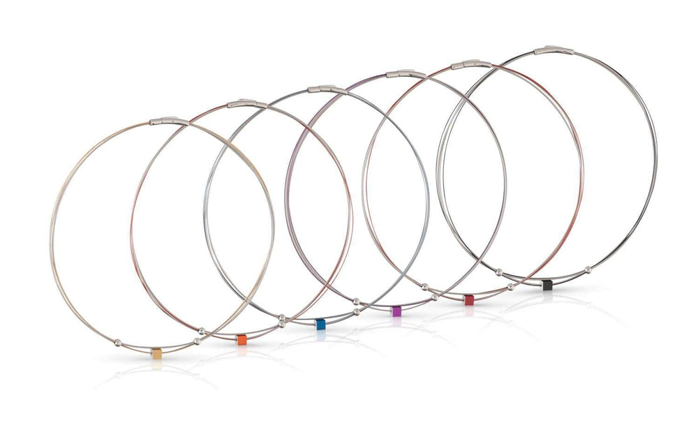 Zeven metalen draad sleutelhangers van CLIC Creations, gemaakt van chirurgisch staal, tonen sluitingen in geel, oranje, rood, paars, blauw, groen en zwart. Getoond op een witte achtergrond met kleine gekleurde kubussen voor charme; één toont het Collier Klein Kubusje Rood C230R ontwerp.