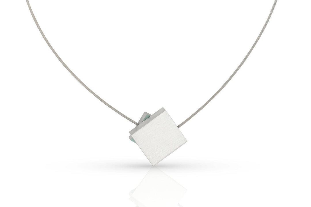 De CLIC Creations Collier Vierkant met gekleurd vierkant C263B heeft een minimalistisch design met een dun zilverkleurig draadje en een geometrische, vierkante hanger die schuin hangt, afgewerkt met een strakke magneetsluiting voor eenvoudig dragen.