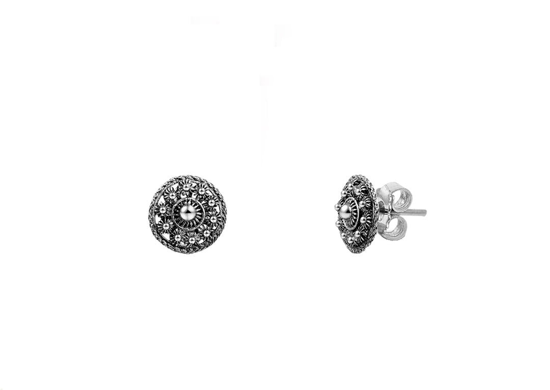De Zeeuwse Knoop Oorstekers Goes 8mm van Dutch Button zijn kleine, ronde zilveren oorstekers met ingewikkelde details, met een centrale steen en decoratieve patronen. Eén oorbel is naar voren gericht, terwijl de andere van de zijkant is afgebeeld om de steker en sluiting te benadrukken.