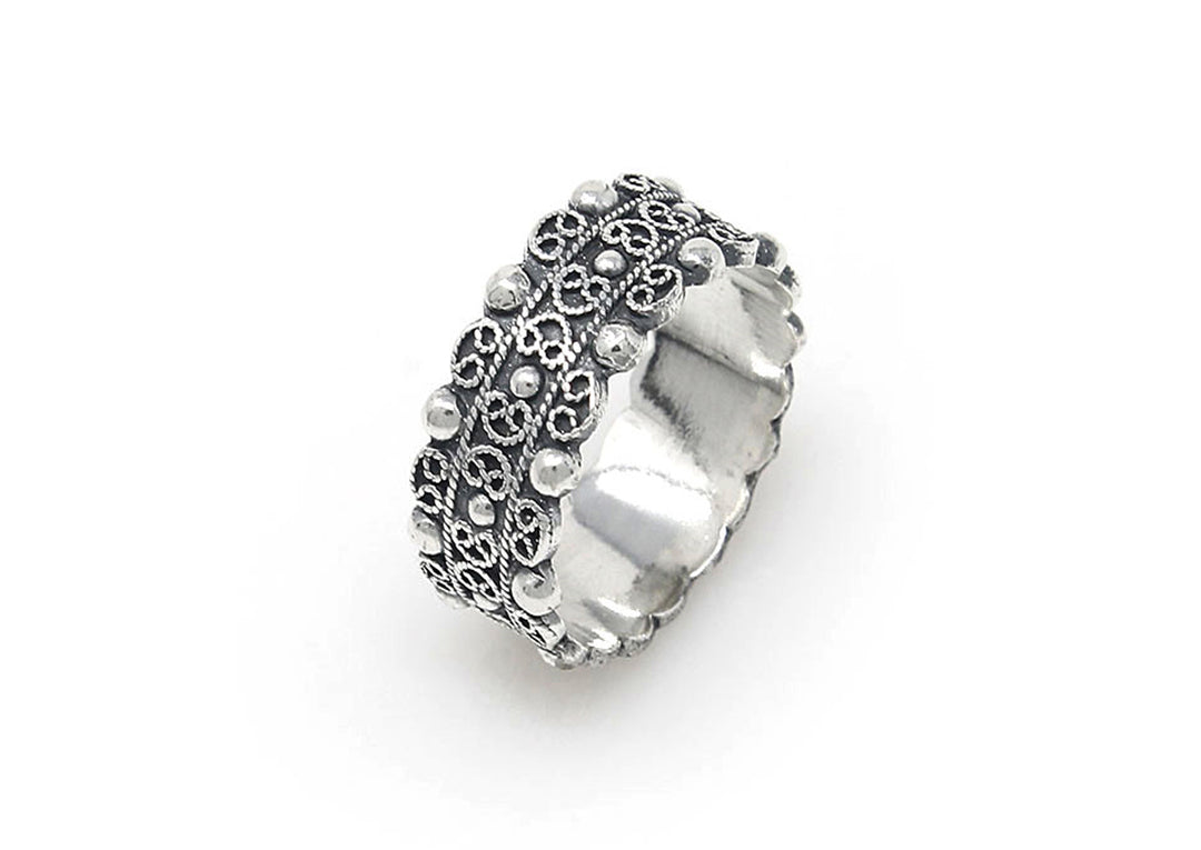 De Zeeuwse Knop Ring Middelburg van Dutch Button is een zilveren ring met ingewikkelde reliëfbloempatronen en kleine ronde accenten, met een gestructureerd en gedetailleerd ontwerp. Het heeft een metalen band met licht afgeronde randen.