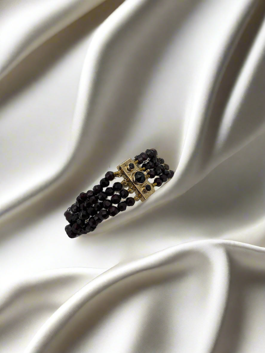 Vintage gouden armband van 14k met granaatstenen, uitgevoerd in een meerlagige stijl.