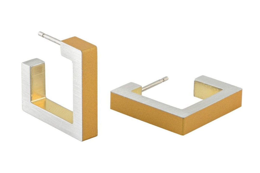 De Vierkante creolen Goud|Geel O11 oorbellen van CLIC Creations hebben een geometrisch ontwerp en zijn gemaakt van hypoallergeen chirurgisch staal met een tweekleurige afwerking: geborsteld zilver aan de buitenkant en mat goud aan de binnenkant. Dit zorgt voor een minimalistische en moderne look.