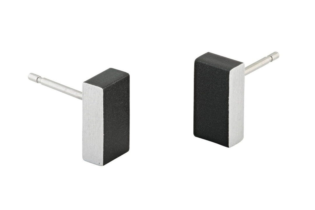 De Oorsteker Rechthoekje Zwart O23Z oorbellen van CLIC Creations hebben een minimalistisch zwart en zilver rechthoekig ontwerp met postbackings, wat zorgt voor een strakke, moderne uitstraling. Handgemaakt in Nederland van hypoallergeen chirurgisch edelstaal, bieden ze ingetogen elegantie met contrasterende kleuren.