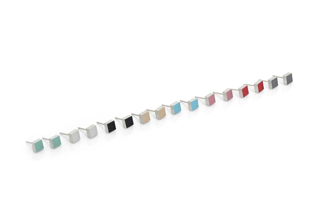 CLIC Creations presenteert de Oorsteker Klein vierkant Grijs O37AG, met 18 lineaire kleurstalen in verschillende kubusvormen, met tinten blauw, rood, zwart, grijs en beige op een witte achtergrond.