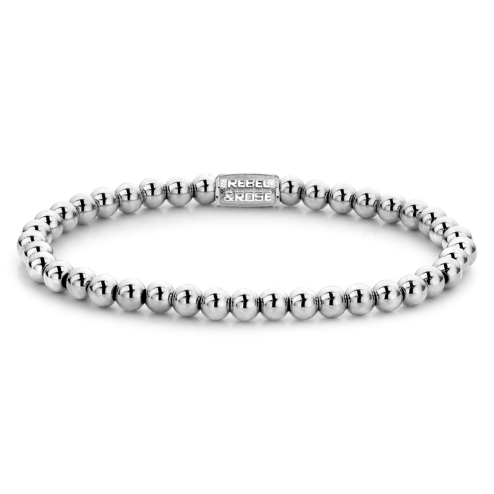 De Silver Shine - 4mm Kralen Armband Dames van Rebel & Rose is een zilveren kralen damesarmband met een rechthoekige sluiting waarin het merk is gegraveerd, elegant afgebeeld op een effen zwarte achtergrond.