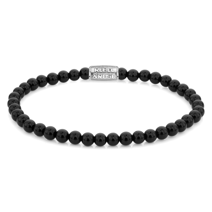 De Rebel & Rose Black Velvet - 4mm Kralen Armband Heren heeft glanzende zwarte kralen en een zilveren rechthoekige bedel met de tekst REBEL & ROSE, elegant gerangschikt in een cirkel op een witte achtergrond.