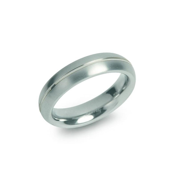 De Boccia Titanium Ring 0130-01 van Boccia heeft een minimalistisch ontwerp met gepolijst titanium, geaccentueerd door een enkele dunne groef rond het midden. Hij wordt schuin weergegeven tegen een effen witte achtergrond.