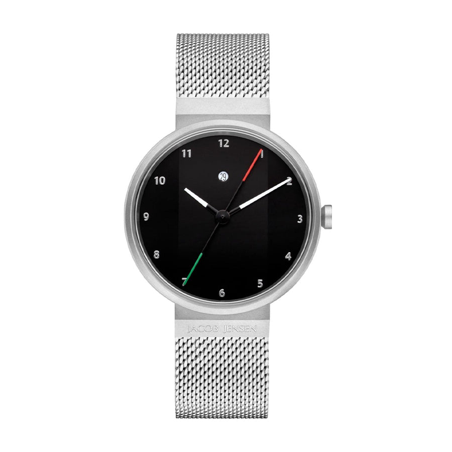 Maak kennis met de Jacob Jensen 780, een minimalistisch polshorloge met een zilveren meshband en een strak zwart gezicht. Het heeft zilveren uurmarkeringen, wijzers, twee dunne gekleurde lijnen in groen en rood, quartzprecisie en een elegant gegraveerde merknaam op de band.