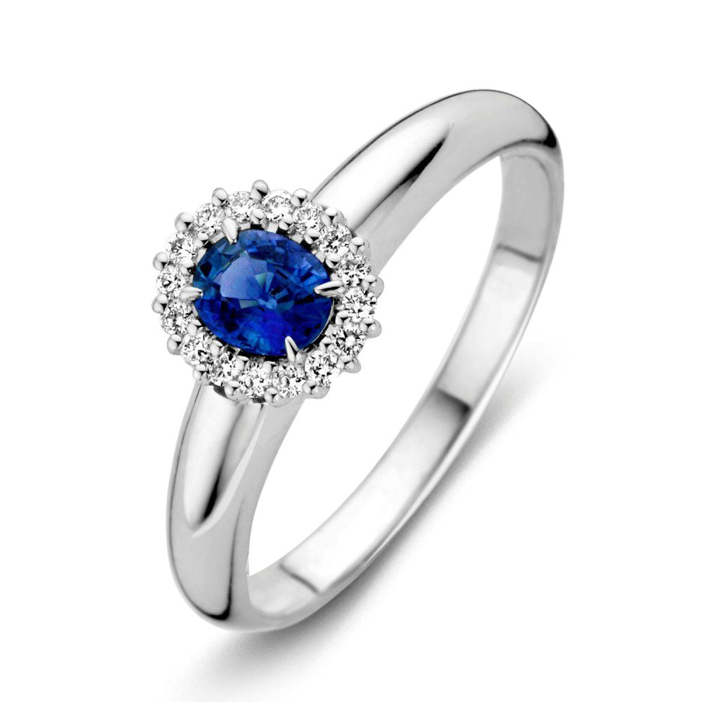 De Witgouden Damesring met Blauwe Saffier en Briljant van Excellent Jewelry straalt tijdloze elegantie uit met een ovale blauwe saffier omringd door een halo van briljanten.