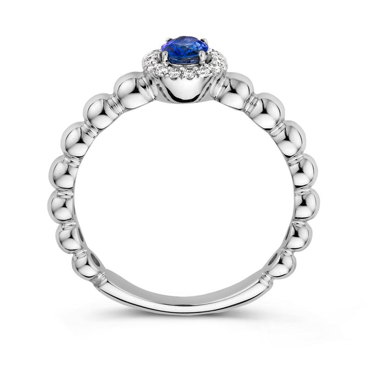 De 14 Karaat Witgouden Rijring met Blauwe Saffier en 0,14 Caraat Diamanten van Excellent Jewelry is afgebeeld op een witte achtergrond, met een ronde blauwe saffier in het midden en omringd door schitterende diamanten.