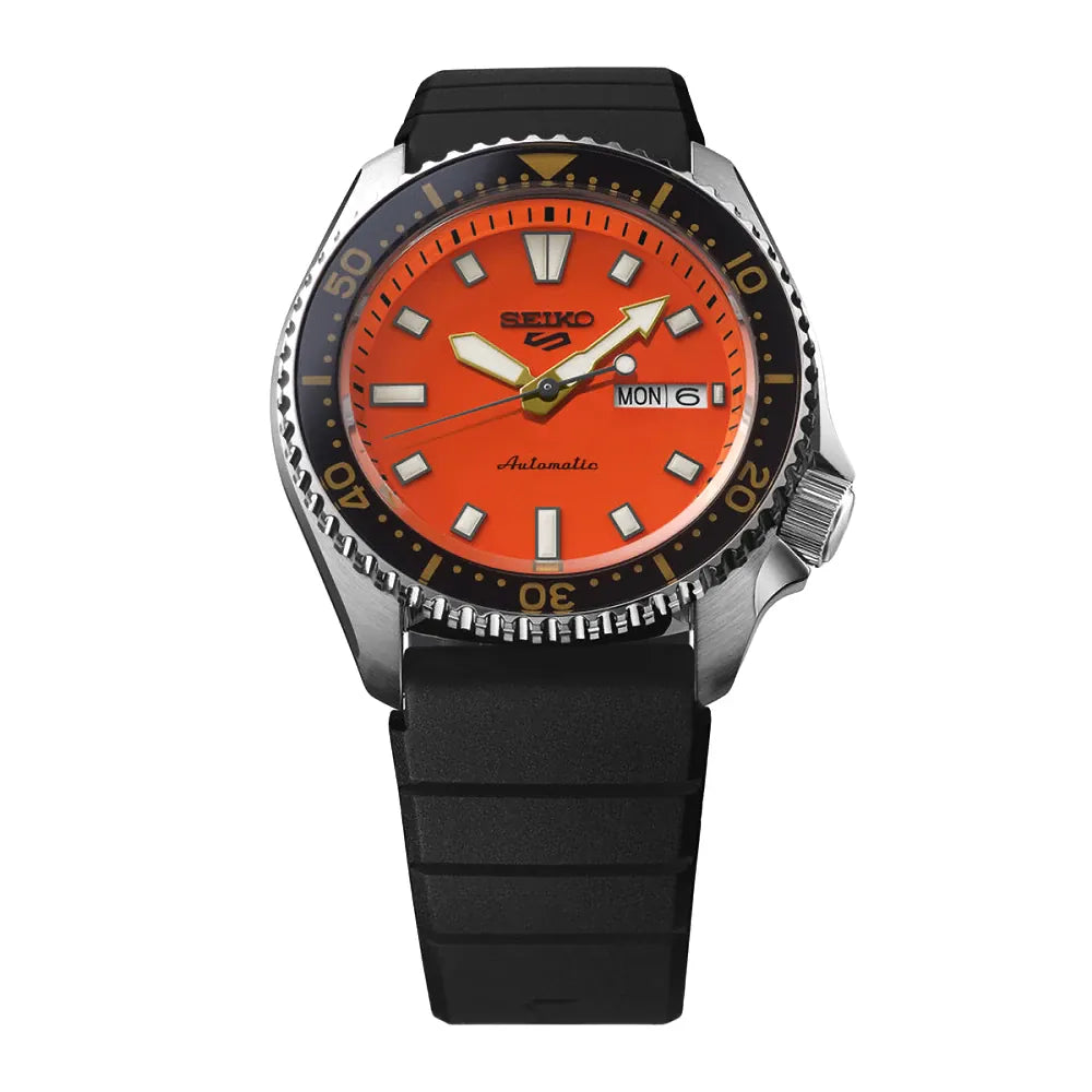 De Seiko 5 Sports heren horloge SRPL89K1 van Seiko heeft een fel oranje wijzerplaat, zilverkleurige en gele wijzers, opvallende witte uurmarkeringen, een zwarte draaibare lunette met gouden accenten en een zwarte rubberen band. Datum en dag staan op 3 uur. Geïnspireerd op de SKX399.
