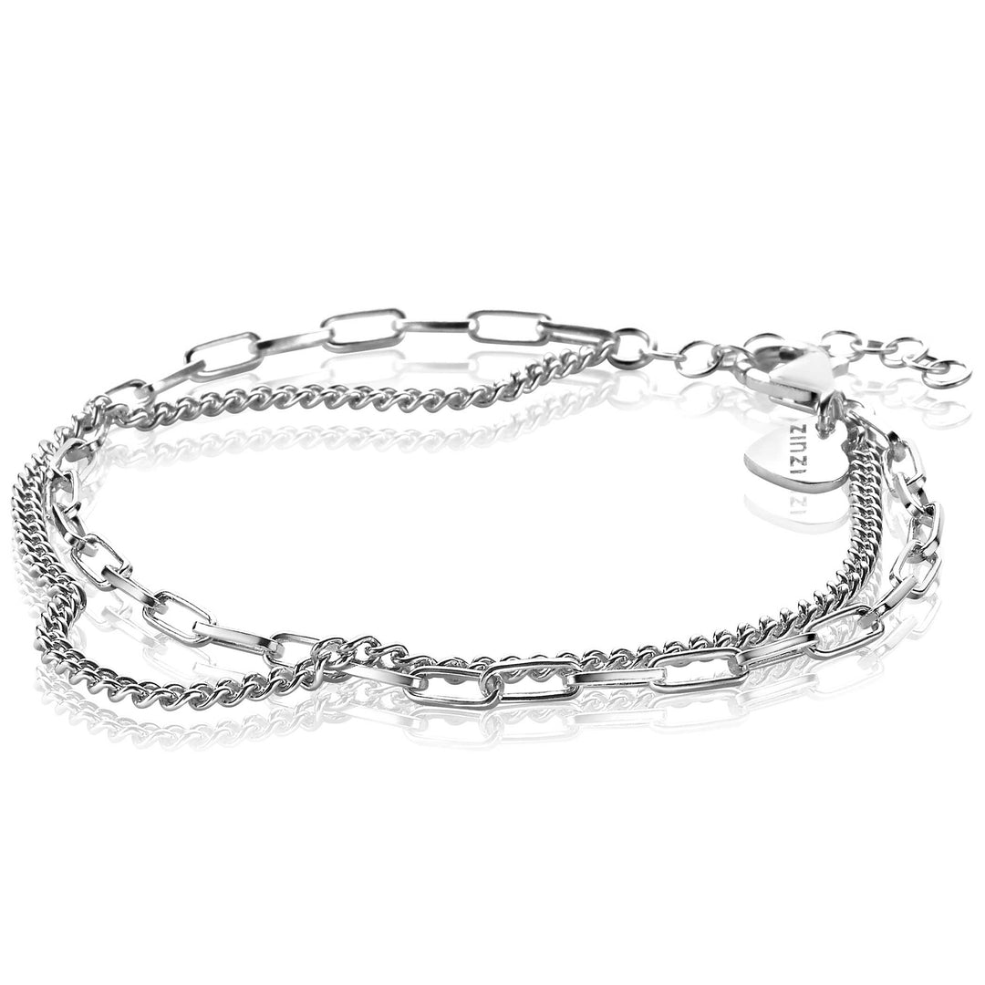 De Zinzi Armband Zilver Zia1988 is een zilveren armband die dikke en dunne schakels combineert, voorzien is van een klein rond bedeltje, een karabijnsluiting heeft en een reflecterend oppervlak op een witte achtergrond heeft.