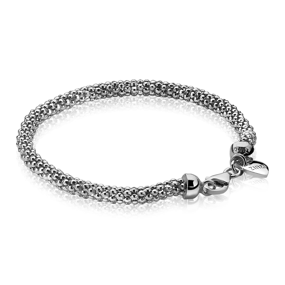 De Zinzi Armband Zilver Zia1057 van Zinzi heeft een zilveren mesh-ontwerp, is 19 cm lang en 5 mm breed. De gestructureerde ketting heeft een veilige sluiting met een klein label, wat een reflecterende aantrekkingskracht creëert tegen de witte achtergrond.
