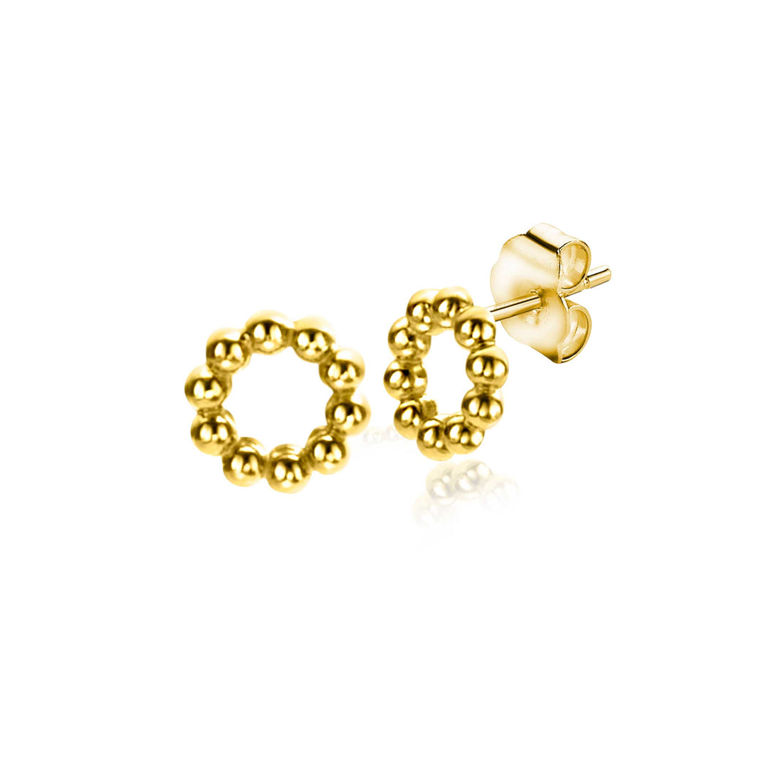 De Zinzi Oorbellen Goud Zgo399 hebben een cirkelvormig bolletjesmotief van kleine kraaltjes, met zichtbare oorbelpaaltjes en vlinderruggen. Het reflecterende oppervlak voegt diepte toe en vangt lichte schaduwen op.