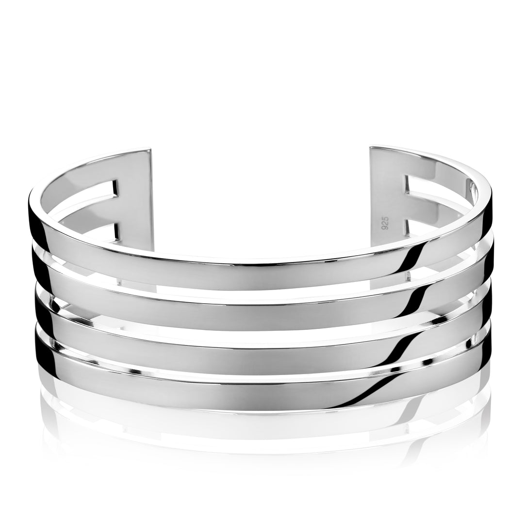 De Zinzi Armband Zilver Mva1 is een glanzende zilveren klemarmband met drie gepolijste horizontale banden. Het strakke, reflecterende oppervlak voegt elegantie toe en het open ontwerp zorgt voor een verstelbare maatvoering. Dit maakt het zowel stijlvol als veelzijdig, een moderne touch van Zinzi.